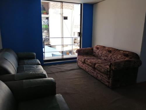 sala de estar con sofá y ventana grande en Habitación Privada con baño privado, en Zamacola