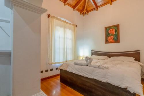 a bedroom with a bed with a cat laying on it at Indian Palace Hotel Boutique Spa & Restaurante in Antigua Guatemala
