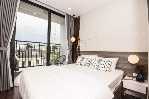 a bedroom with a white bed and a large window at Studio cao cấp Vinhomes Greenbay Mễ trì giá rẻ nhất Hà Nội in Hanoi