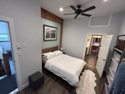 een slaapkamer met een bed en een plafondventilator bij Charming Hidden Gem- Ocean View and Marina in Campbell River