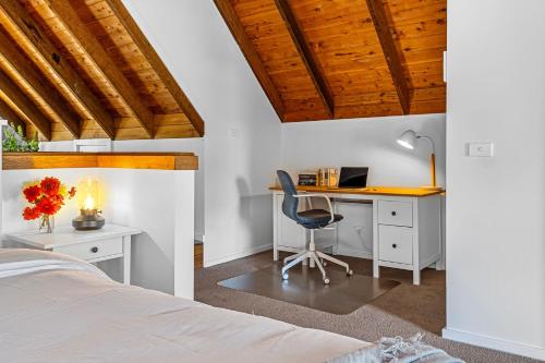 a bedroom with a desk and a bed with a chair at Ellendale in Kurmond