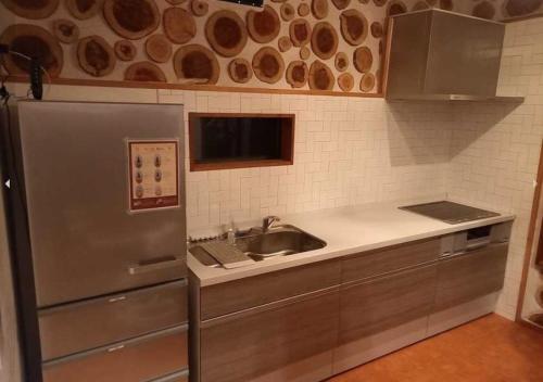 cocina con nevera de acero inoxidable y fregadero en Umidori - Vacation STAY 48513v en Hongō