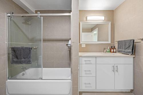 y baño con ducha, bañera y lavamanos. en Upper East Side Luxury 3BR 2B, en Nueva York