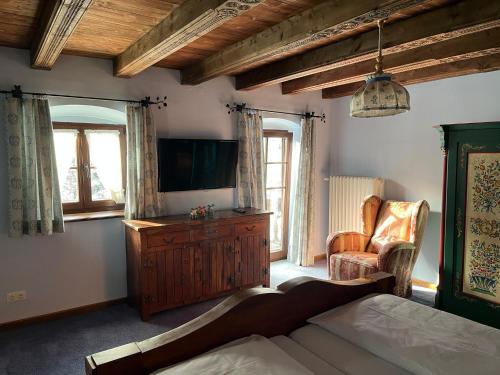 a living room with a bed and a television at St. Anton in Grainau