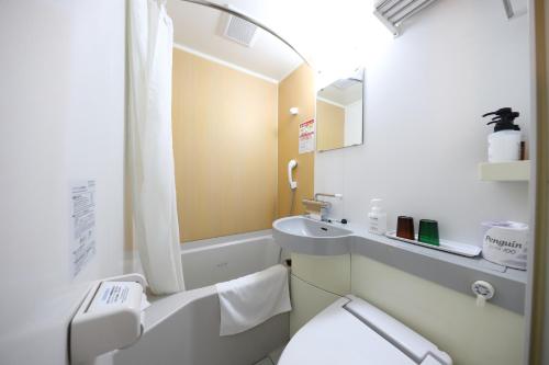 a white bathroom with a sink and a toilet at Smile Hotel Kyoto Karasuma Gojo in Kyoto