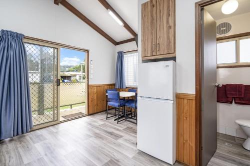 a kitchen with a refrigerator and a table at Teralba Lakeside Caravan Park in Teralba