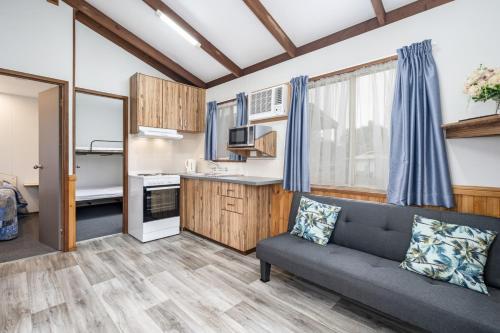 a living room with a couch and a kitchen at Teralba Lakeside Caravan Park in Teralba