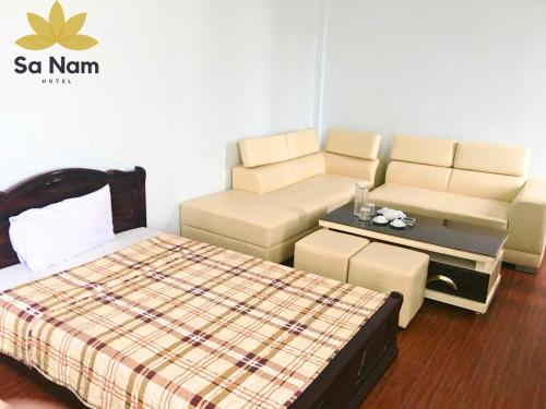 Thương Xà (2)にあるKhách sạn Sa Nam Cửa Lòのベッド、ソファ、テーブルが備わる客室です。