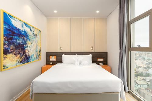 een slaapkamer met een wit bed en een groot raam bij GRAND CITIVIEW DANANG in Da Nang