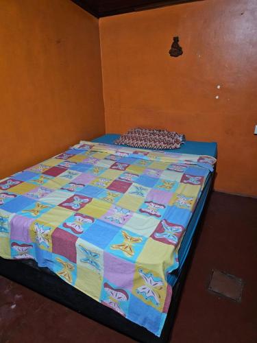 a bed with a colorful quilt on it in a room at alojamiento Villa sarita in Posadas