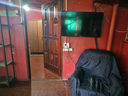 a room with a tv and a bed and a door at alojamiento Villa sarita in Posadas