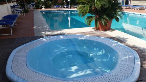 a large blue tub sitting next to a swimming pool at Hotel Splendid in Diano Marina