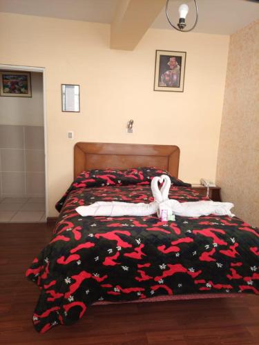 a bedroom with a bed with a stuffed animal on it at Hotel Lizarraga in La Paz