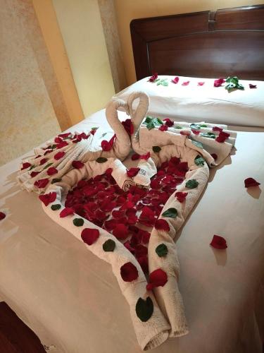 a bed covered in red rose petals and hearts at Hotel Lizarraga in La Paz