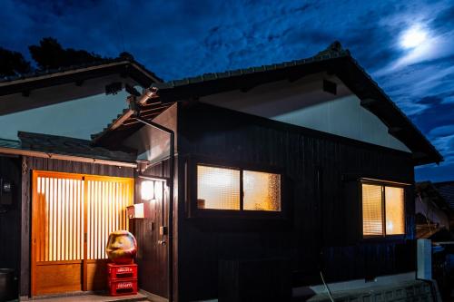 una casa con una puerta delantera por la noche en Naoshima Juju Art House　直島ジュジュアートハウス, en Naoshima