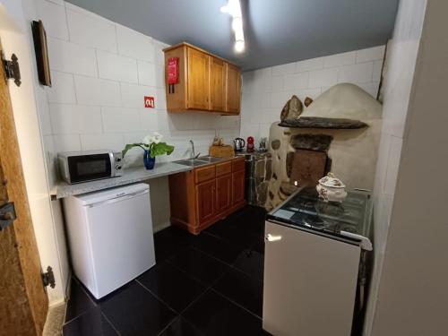 uma pequena cozinha com um fogão e um frigorífico em Casa do Forno F.R em Barreiro