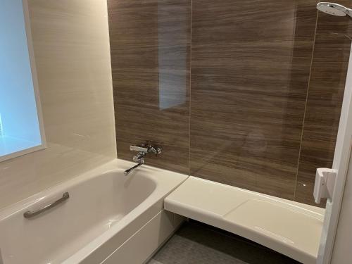 a bathroom with a bath tub and a sink at HOTELウォーターゲート蟹江（カップル専用） in Kanie