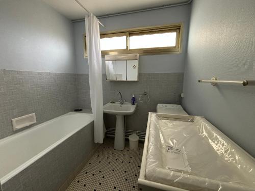 une salle de bain avec une baignoire, un lavabo et des toilettes dans l'établissement Appartement 4 pièces avec balcon face mer, proche plage et commerces, idéal famillies - FR-1-197-199, à Les Sables-dʼOlonne