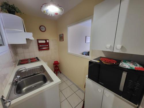 cocina con fregadero y microondas en Appartement Les Sables-d'Olonne, 2 pièces, 4 personnes - FR-1-92-575, en Les Sables-dʼOlonne