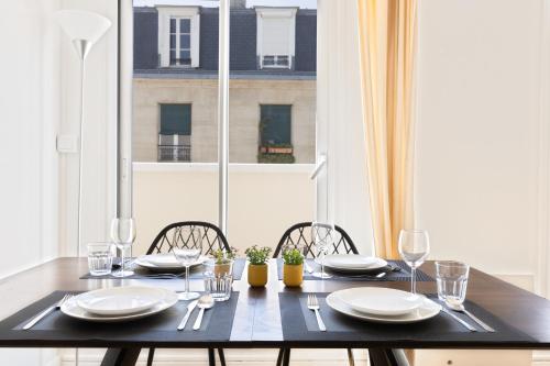 une table de salle à manger avec vue sur une fenêtre dans l'établissement Appartement Quartier Luxembourg Free Netflix, à Paris