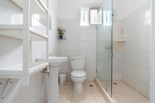 a bathroom with a toilet and a sink and a shower at Casa cerca SDQ & Bus Caribe tours in Santo Domingo