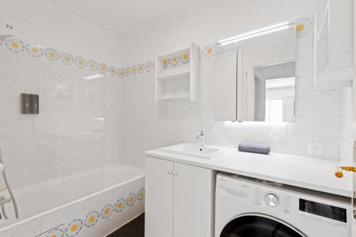 La salle de bains blanche est pourvue d'un lavabo et d'un lave-linge. dans l'établissement Appartement Quartier Luxembourg Free Netflix, à Paris