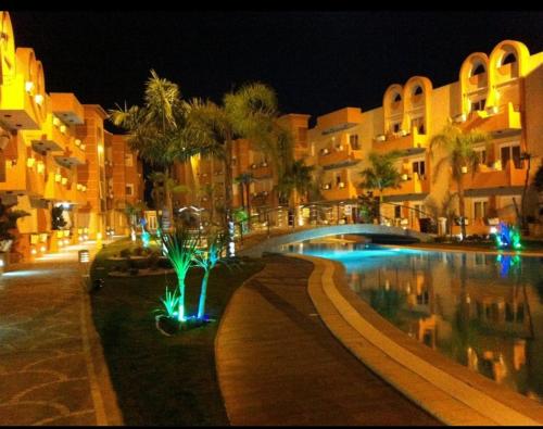 un complejo con piscina por la noche en Résidence dunes du golf kantaoui en Sousse