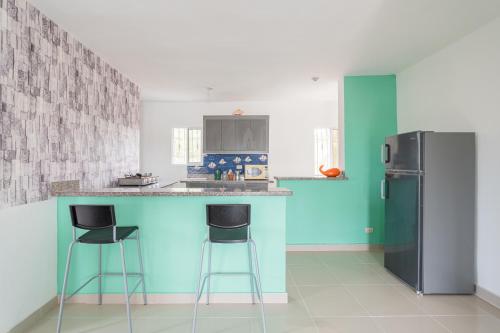 a kitchen with a blue counter and a refrigerator at Mi refugio cerca del aeropuerto in Santo Domingo