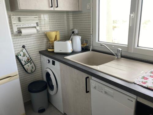 une cuisine avec un évier et une machine à laver dans l'établissement Appartement 4 Pers, Plage et Commerces à Proximité, Garage Inclus - FR-1-323-32, à Saint-Jean-de-Monts