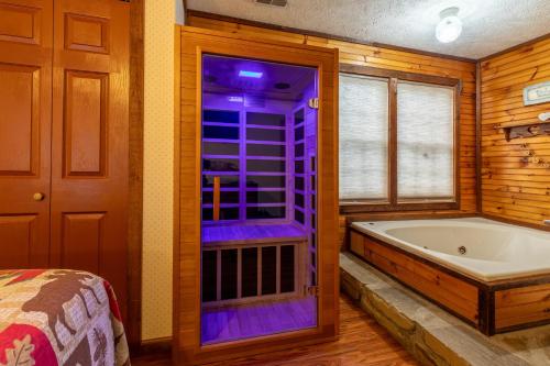 a bathroom with a bath tub and a window at Real Log Cabin With Amazing Views, Hot Tub, Sauna, Games in Gatlinburg