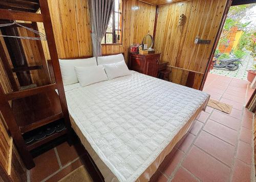 a large bed in a room with wooden walls at Kara Homestay & Cafe in Can Tho