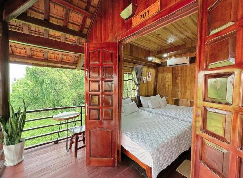 een slaapkamer met een bed en een balkon bij Kara Homestay & Cafe in Can Tho