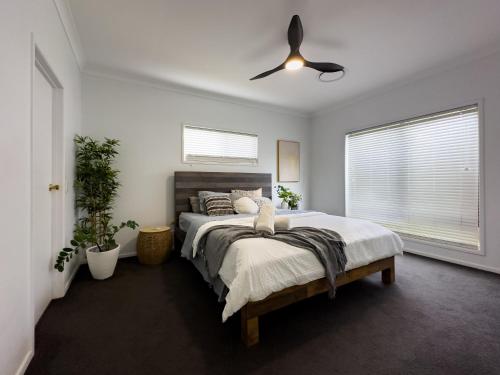 a bedroom with a bed and a ceiling fan at Shailer Park Serenity in Tanah Merah