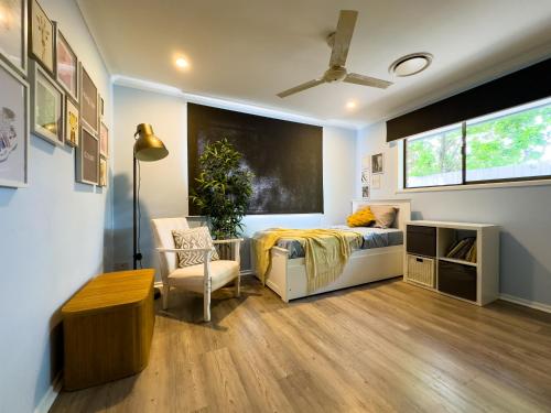 sypialnia z łóżkiem, krzesłem i oknem w obiekcie Shailer Park Serenity w mieście Tanah Merah
