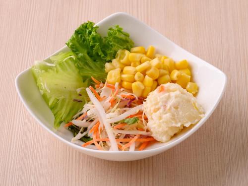 a bowl of food with carrots corn and lettuce at Centre One Hotel Handa in Handa