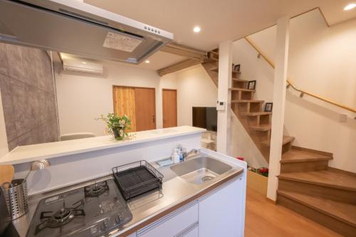a kitchen with a sink and a staircase at 和居 東桜 静かで落ち着く 大阪城近くの好立地物件 in Osaka