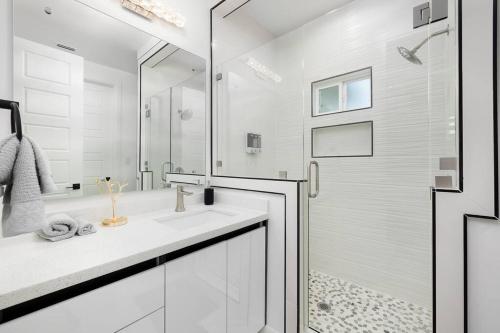 a white bathroom with a shower and a sink at Quinta Real 4905 in McAllen