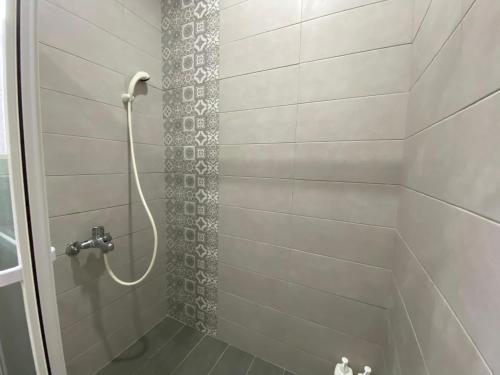 y baño con ducha con cabezal de ducha. en Housha Homestay, en Jinning