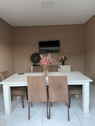 una sala da pranzo con tavolo e sedie bianchi di Casa com piscina e churrasqueira a Bonito