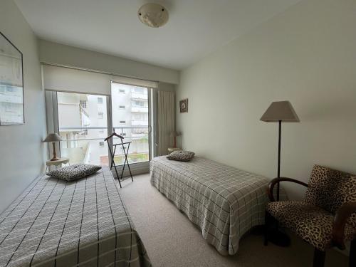 une chambre avec deux lits et une chaise et une fenêtre dans l'établissement Appartement T3 Central à Arcachon avec Vue Mer, Terrasse, Wifi et Parking - FR-1-374-52, à Arcachon