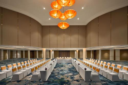 an empty banquet hall with white chairs and orange chandeliers at Wyndham Hoi An Royal Beachfront Resort & Villas in Hoi An