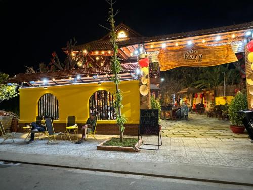 a yellow house with lights on it at night at Kara Homestay & Cafe in Can Tho