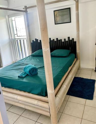 ein Schlafzimmer mit einem Bett mit einem Holzrahmen in der Unterkunft Très Spacieux T2 hyper centre in Kourou