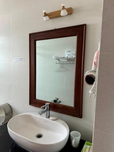 a bathroom with a sink and a mirror at Hoàng Khiêm Hotel in Pleiku
