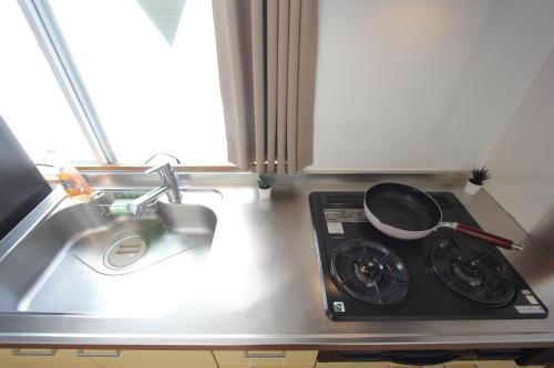 東京にあるルアナ錦ビルの洗面台横の鍋付きコンロ