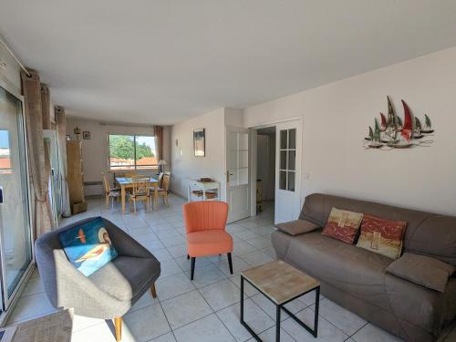 un salon avec un canapé et une chaise dans l'établissement Centre Arcachon - Grand T3 Calme, Lumineux avec Terrasse et Parking, Proche Plages et Commerces - FR-1-420-8, à Arcachon