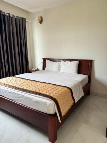 a bedroom with a large bed with a wooden headboard at Hoàng Khiêm Hotel in Pleiku