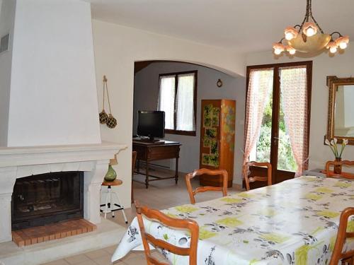 une salle à manger avec une table et une cheminée dans l'établissement Maison avec grand jardin à 40m de la plage, prox. centre-ville, 3 ch, terrasse plein sud - FR-1-22-255, à La Tranche-sur-Mer