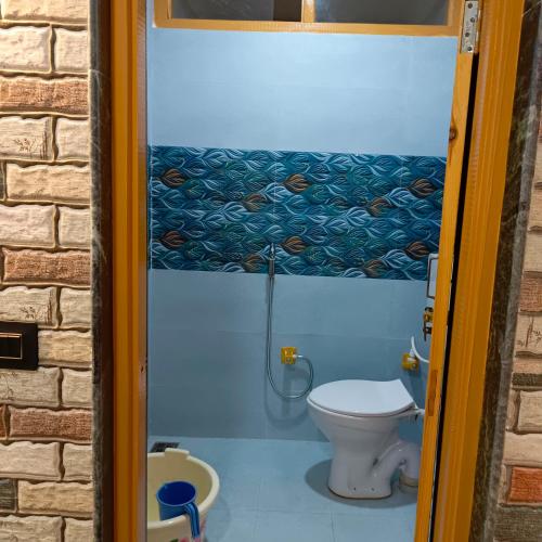 a bathroom with a toilet and a shower at The Himalayan Inn homestay in Gulmarg