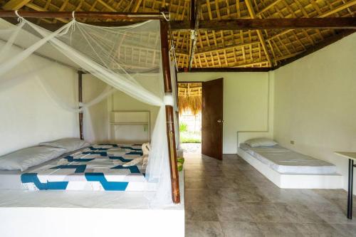 A bed or beds in a room at Private Beachescape - Amansinaya Beachhouse Mindoro